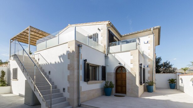 A two-story house with a staircase, a wooden door, and potted plants. - Beachfront Villa With Pool, Puerto Pollenca (Pollença)