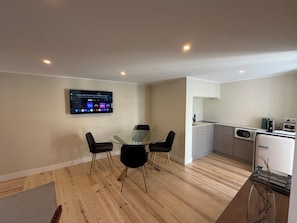 A modern kitchen with a built-in microwave and a small refrigerator.