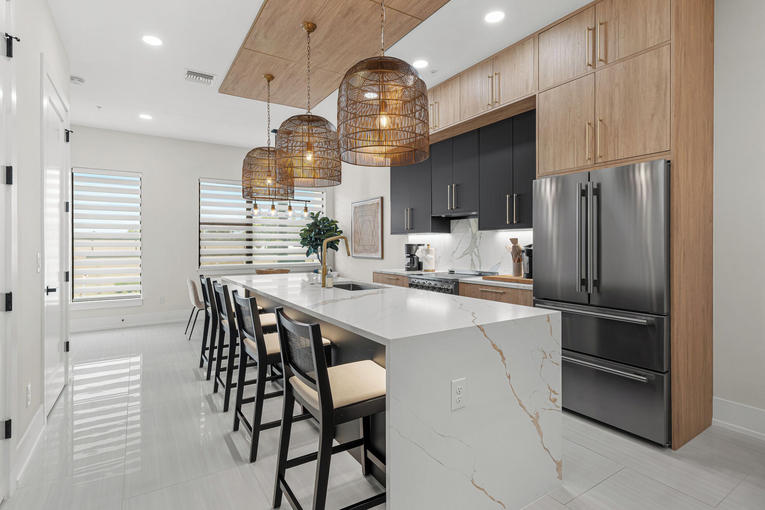 A modern kitchen with a central island, stainless steel appliances, and wooden cabinetry.