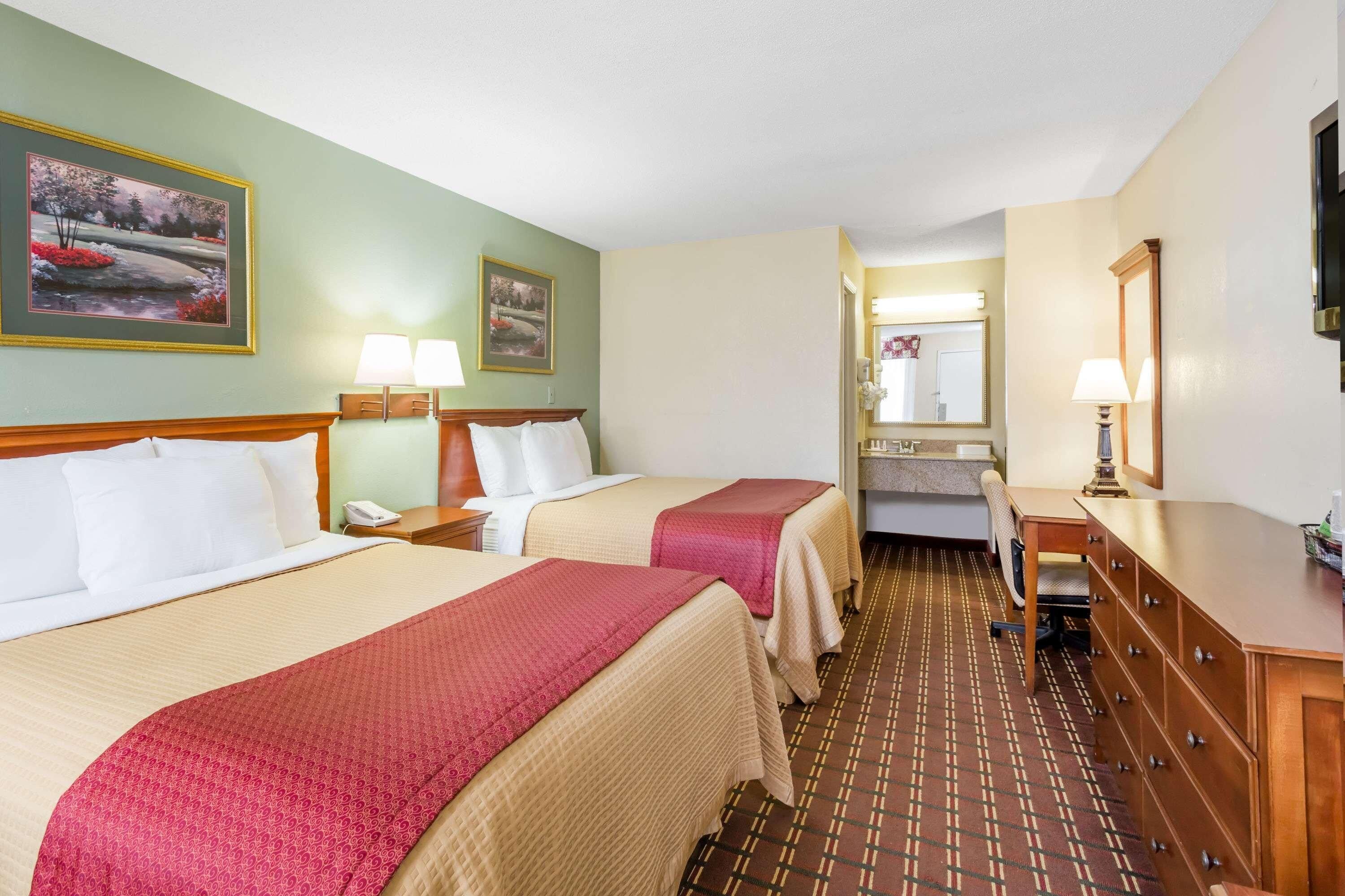 Une chambre d’hôtel avec deux lits, une salle de bain et un bureau.