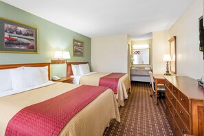 Habitación de hotel con dos camas, un baño y un escritorio.