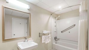 A bathroom with a sink, mirror, shower, and towel rack. - Days Inn by Wyndham Orangeburg (Orangeburg)