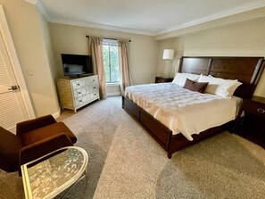 A hotel room with a bed, a TV, a dresser, and a chair.