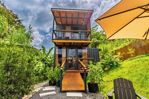 A modern two-story wooden structure with a balcony, surrounded by lush greenery. - Tranquilandia Estate-Private Villas Retreat (Río Grande)