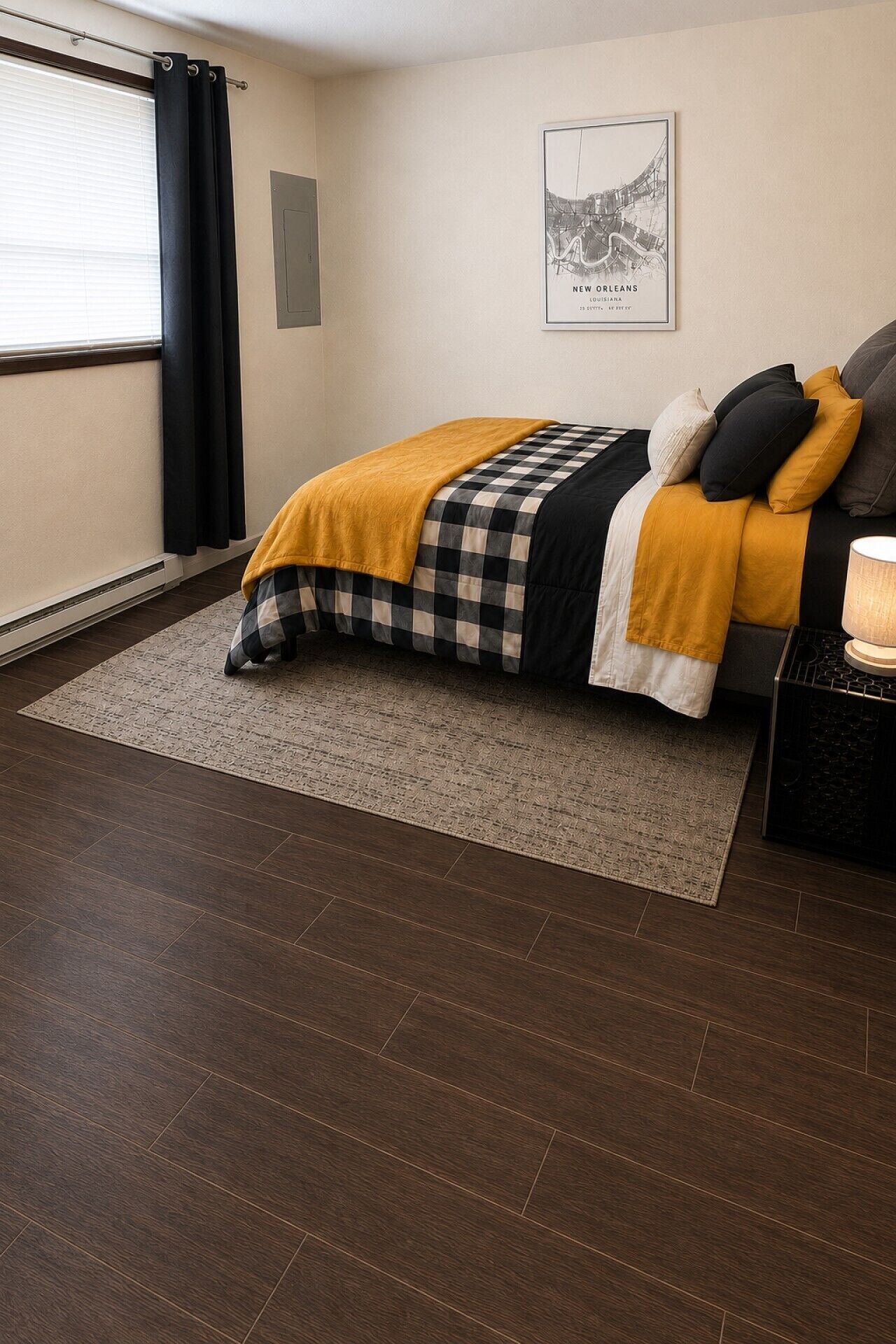 A bedroom with a bed, a rug, a nightstand, and a wall-mounted picture.