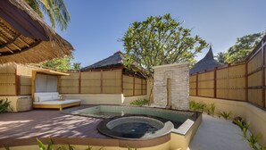 Un'area benessere con vasca idromassaggio, posti a sedere e piscina.