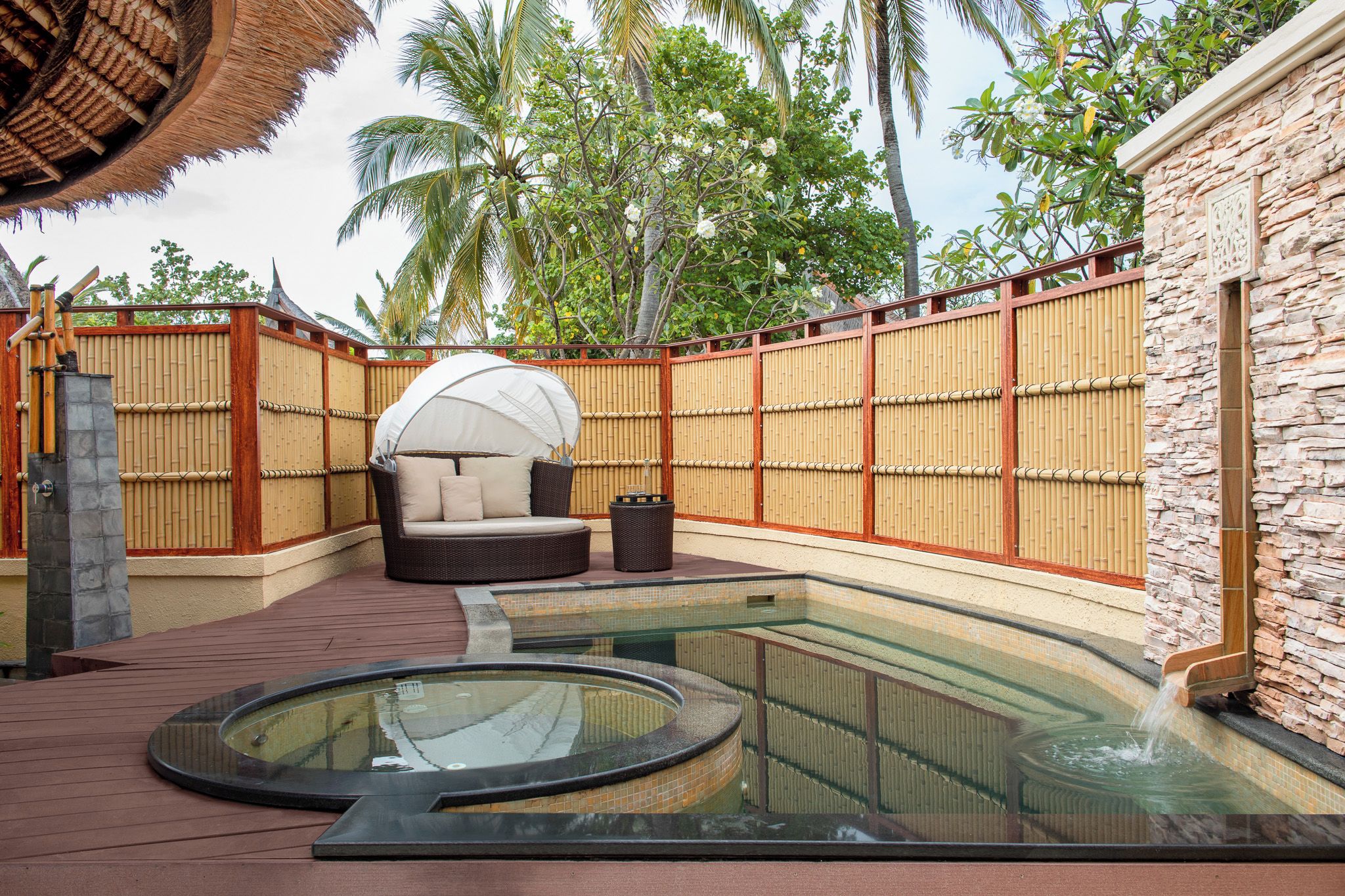 A spa area with a hot tub, a seating area, and a pool.