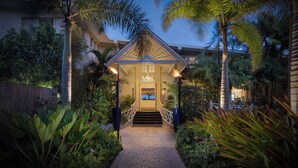 A well-lit entrance with a covered staircase leading to a building, surrounded by lush tropical plants. - Sea Breeze Beach House All Inclusive by Ocean Htls (CHRIST CHURCH)