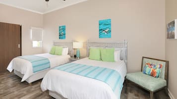 Quarto de hotel com duas camas, uma cadeira e obras de arte nas paredes.