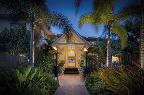 A well-lit entrance with a covered staircase leading to a building, surrounded by lush tropical plants. - Sea Breeze Beach House All Inclusive by Ocean Htls (CHRIST CHURCH)