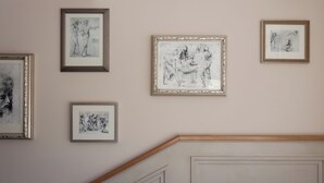 Eine Wand mit fünf gerahmten Kunstwerken.