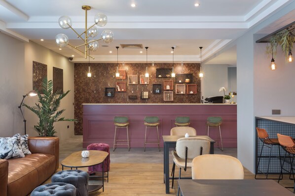 Een modern interieur met een bar, zitgedeelte en een decoratieve wand met sleutelvormen.