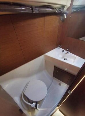 A compact bathroom with a toilet, sink, and cabinet. - Oceanis 40.1 - 4D cab - DORY (Pomer)