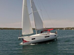A sailboat with a white hull and red accents, sailing on calm waters. - Oceanis 40.1 - 4D cab - DORY (Pomer)