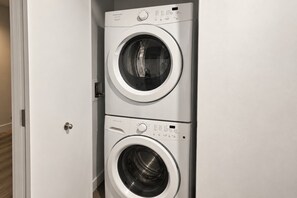 Un modèle de lave-linge compact, à deux portes et à chargement frontal, installé dans un couloir.