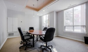 A conference room with a round table, four chairs, and large windows. - Stylish 1BR+Den Retreat in Markham (Markham)