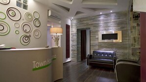 A reception area with a reception desk, a sofa, and a wall-mounted TV.