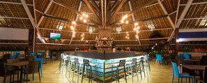 A restaurant with a high ceiling, a central bar area, and multiple seating arrangements.