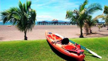 Un bote en un área verde con playa y palmeras al fondo.