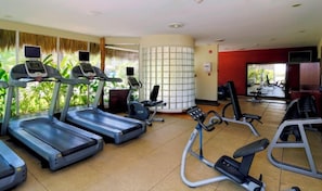 A gym with treadmills, elliptical machines, and weight benches.