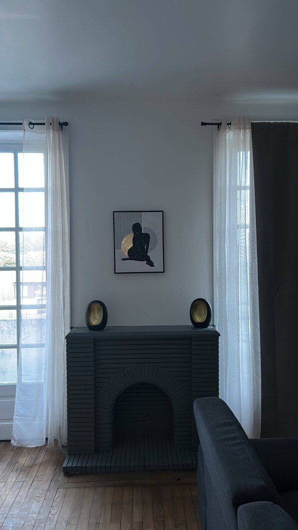 A living room with a fireplace, a framed artwork, and a sofa.