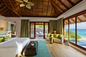 Habitació d'hotel amb un llit, un sofà, una taula de cafè i vista a l'oceà.