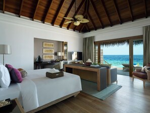 Habitación de hotel con cama, escritorio y vista al océano.