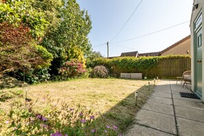 A residential garden with a lawn, various shrubs, and flowering plants. - Kirkmay Road (No 18)  Mayfield House | Crail (Crail)