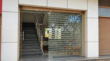 A building entrance with a glass door, a metal staircase, and a view of the outside.