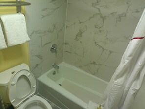 A bathroom with a toilet, a bathtub, and a shower curtain. - Days Inn By Wyndham Hampton Near Coliseum Convention Center (Hampton)