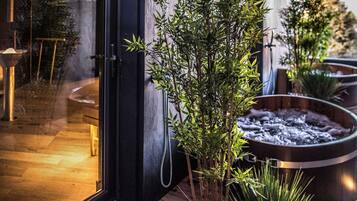 A modern bathroom with a glass door, a bamboo plant, and a heated floor.