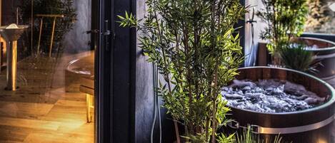 A modern bathroom with a glass door, a bamboo plant, and a heated floor.