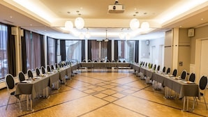 Una sala de conferencias con una larga mesa, sillas y un proyector.