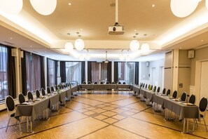 A conference room with a long table, chairs, and a projector. - Everness Hotel and Resort (Chavannes-de-Bogis)