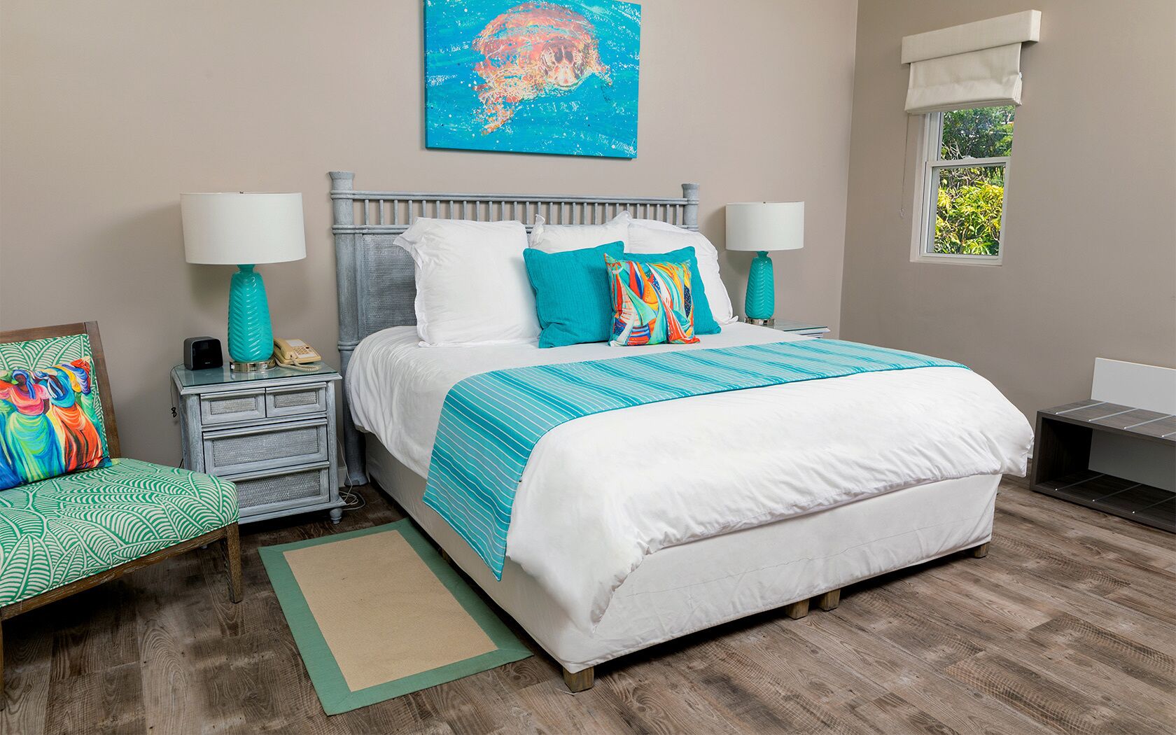 A bedroom with a bed, nightstands, a chair, a window, and a painting on the wall.