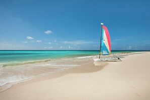 A beach with a sailboat and calm turquoise waters. - Sea Breeze Beach House (Oistins)