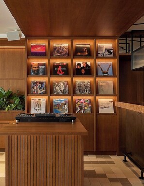 A reception area with a wooden desk and a wall displaying various framed items. - K+K Hotel Maria Theresia (Vienna)