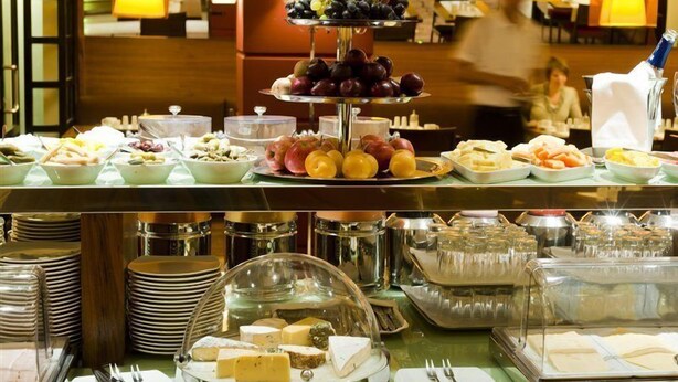 A buffet setup with various food items and utensils. - K+K Hotel Maria Theresia (Vienna)