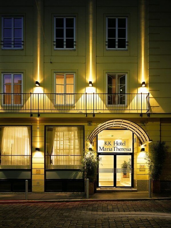 A hotel facade with illuminated windows, a prominent entrance, and a sign reading 'KK Hotel Maria Theresia.' - K+K Hotel Maria Theresia (Vienna)