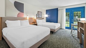A hotel room with two beds, a desk, a chair, and a view of the outdoors. - District 3 Hotel Ascend Hotel Collection (Chattanooga)
