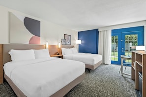 A hotel room with two beds, a desk, a chair, and a view of the outdoors. - District 3 Hotel Ascend Hotel Collection (Chattanooga)