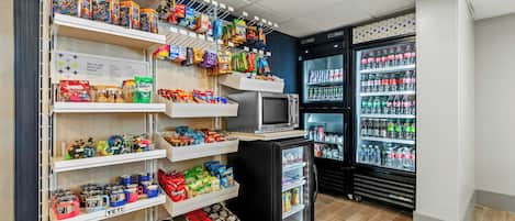 A snack and beverage section with a microwave, refrigerator, and various packaged goods.