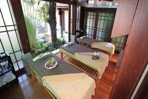 Um quarto em estilo japonês tradicional, com piso de tatame, dois tatames e uma pequena mesa com uma bandeja de frutas.