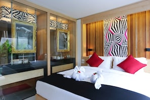 A hotel room with a bed, two mirrors, a wooden panel wall, and a zebra-patterned wall. - Pavilion Samui Villas And Resort (Koh Samui)