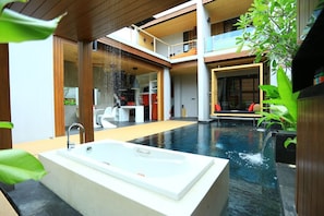Piscina interior moderna con jacuzzi, arquitectura de madera y un área de comedor.