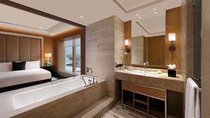 Un bagno moderno con una grande vasca da bagno, un doppio lavabo e uno specchio ampio.