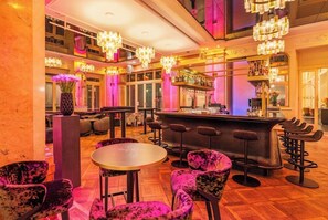 Una zona de bar con diversas opciones de asientos, incluyendo mesas redondas y taburetes.