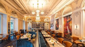A spacious restaurant with high ceilings, ornate chandeliers, and a central bar area. - Schweizerhof (Lucerne)