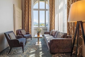 A room with a sofa, two armchairs, a small table with a vase, and a lamp. - Schweizerhof (Lucerne)