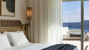 Quarto de hotel com uma cama, vista para o mar e um quadro na parede.